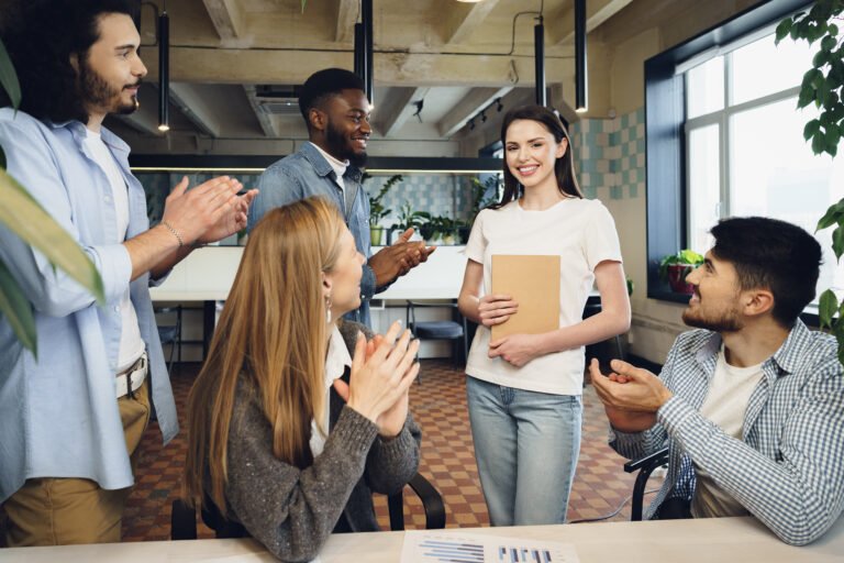 Collègues applaudissant une collaboratrice après sa présentation